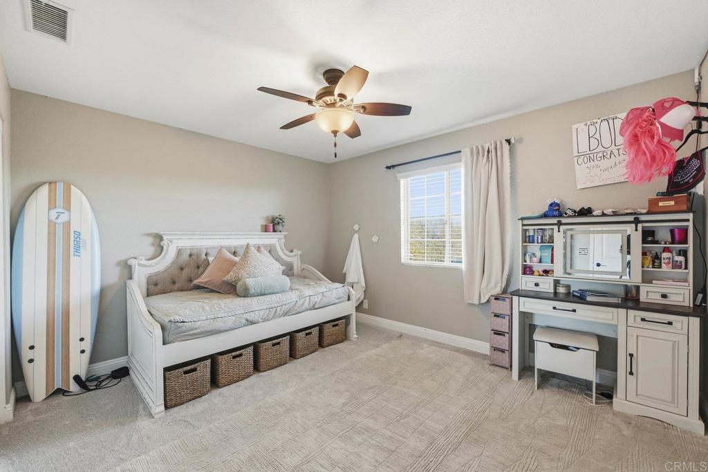 13638 West Oak Glen Road Valley Center, CA 92082 - Photo 23 of 30 a bedroom with a bed and a chandelier