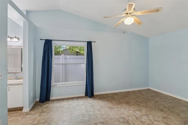 an empty room with windows and fan