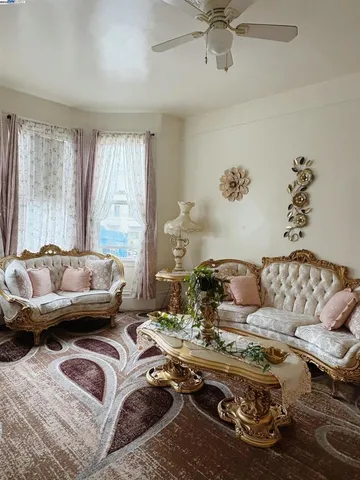 a living room with furniture a chandelier and a rug