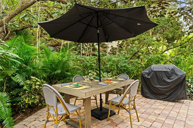 a view of a patio with furniture and umbrella