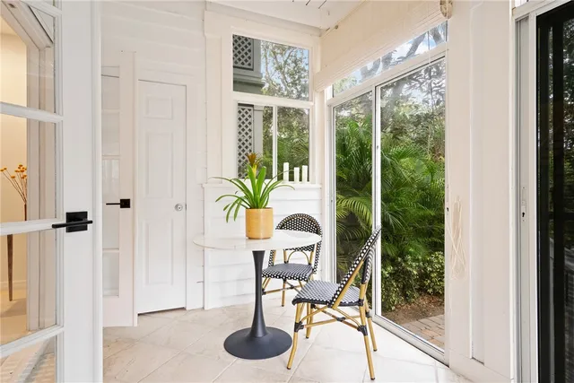 a dining room with furniture and a floor to ceiling window