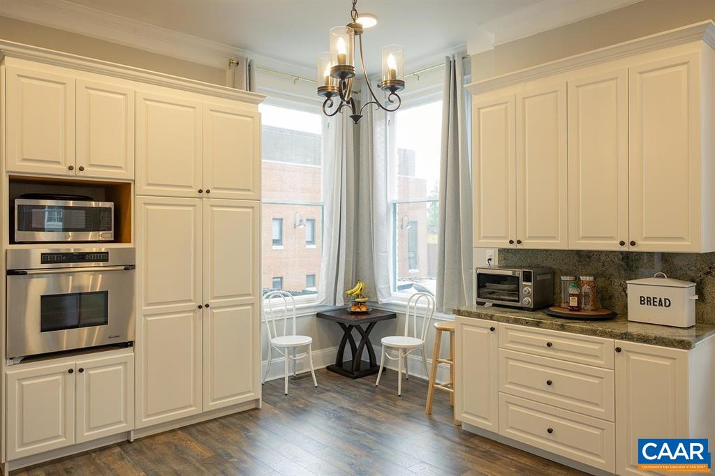 409 Park Street Charlottesville, VA 22902 - Photo 16 of 58 a kitchen with kitchen island granite countertop a stove a refrigerator a sink dishwasher and white cabinets with wooden floor
