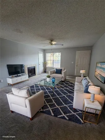 a living room with furniture a flat screen tv and a large window