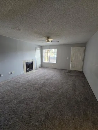 an empty room with windows and fireplace