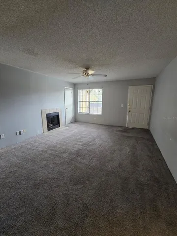 an empty room with windows and fireplace