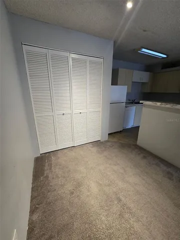 a view of an empty room with a kitchen