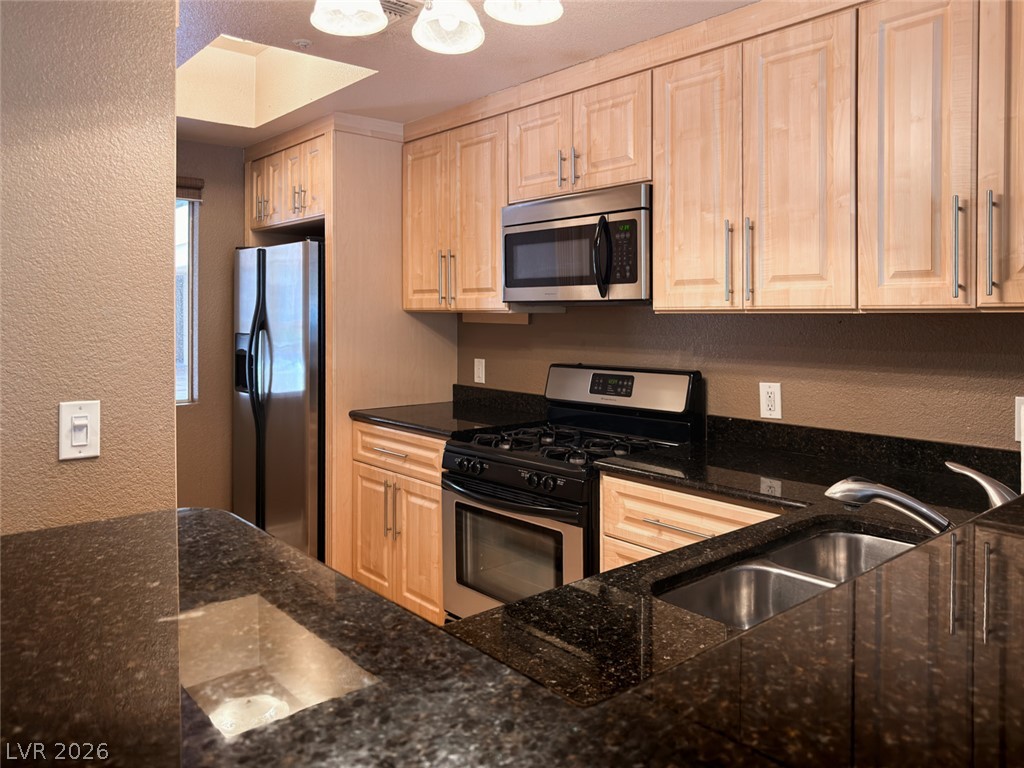 210 East Flamingo Road, Unit 112 Las Vegas, NV 89169 - Photo 6 of 59 Polished granite countertops complement warm wood cabinetry in this well-appointed kitchen.