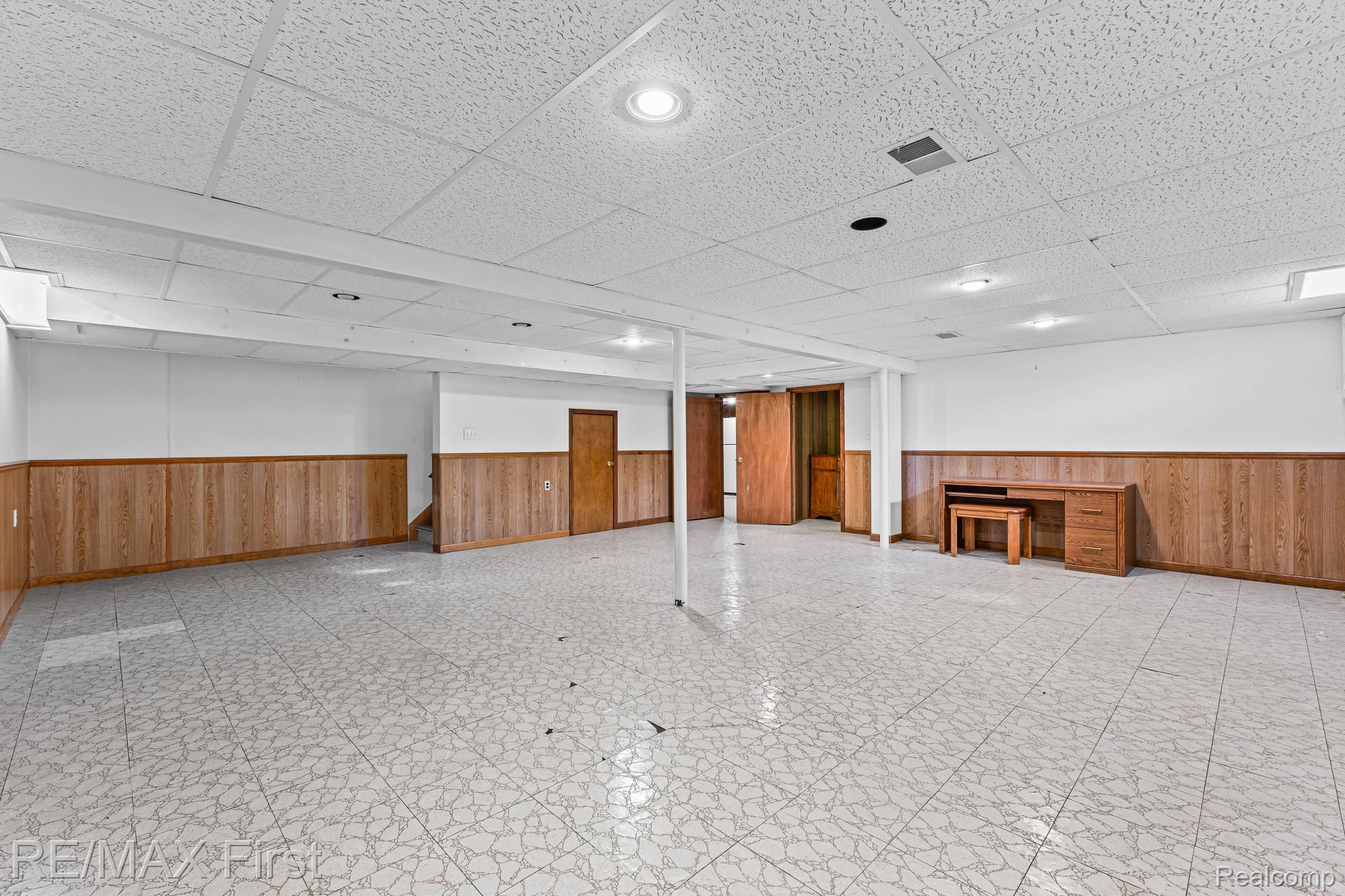 34356 Greentrees Road Sterling Heights, MI 48312 - Photo 24 of 40 Finished basement featuring a drop ceiling, wooden walls, a wainscoted wall, and tile patterned floors