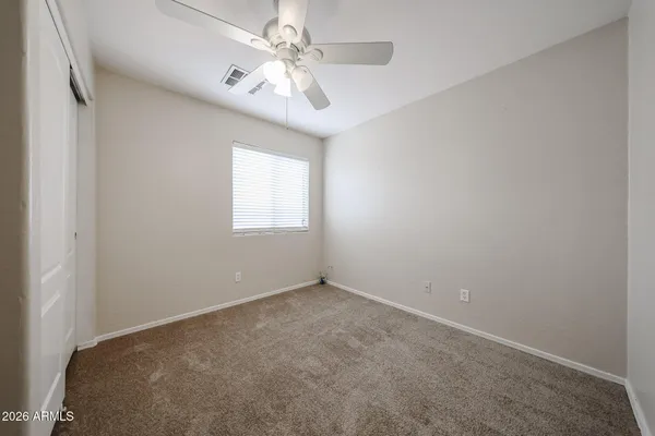 en empty room with windows and ceiling fan