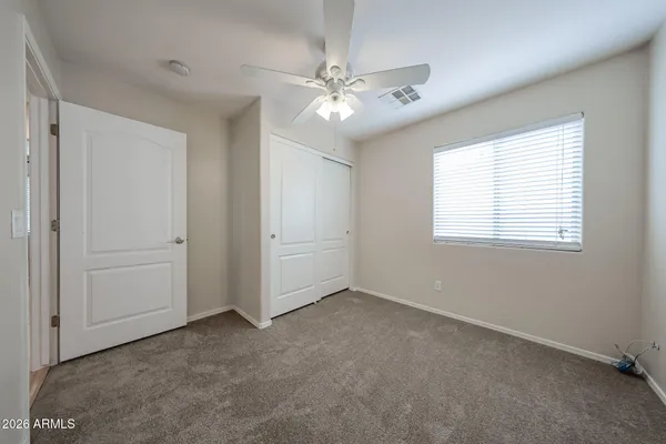 a view of an empty room with a chandelier fan