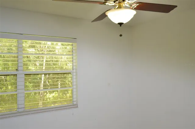 a view of a room with a ceiling fan and a window