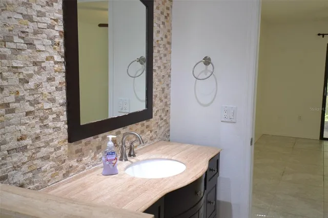 a bathroom with a granite countertop sink and a mirror