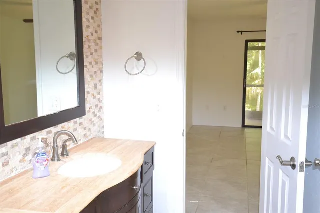 a bathroom with a granite countertop sink and a mirror