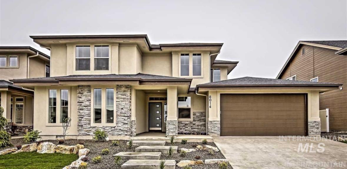 Prairie-style home featuring stucco siding, stone siding, concrete driveway, a garage, and a porch