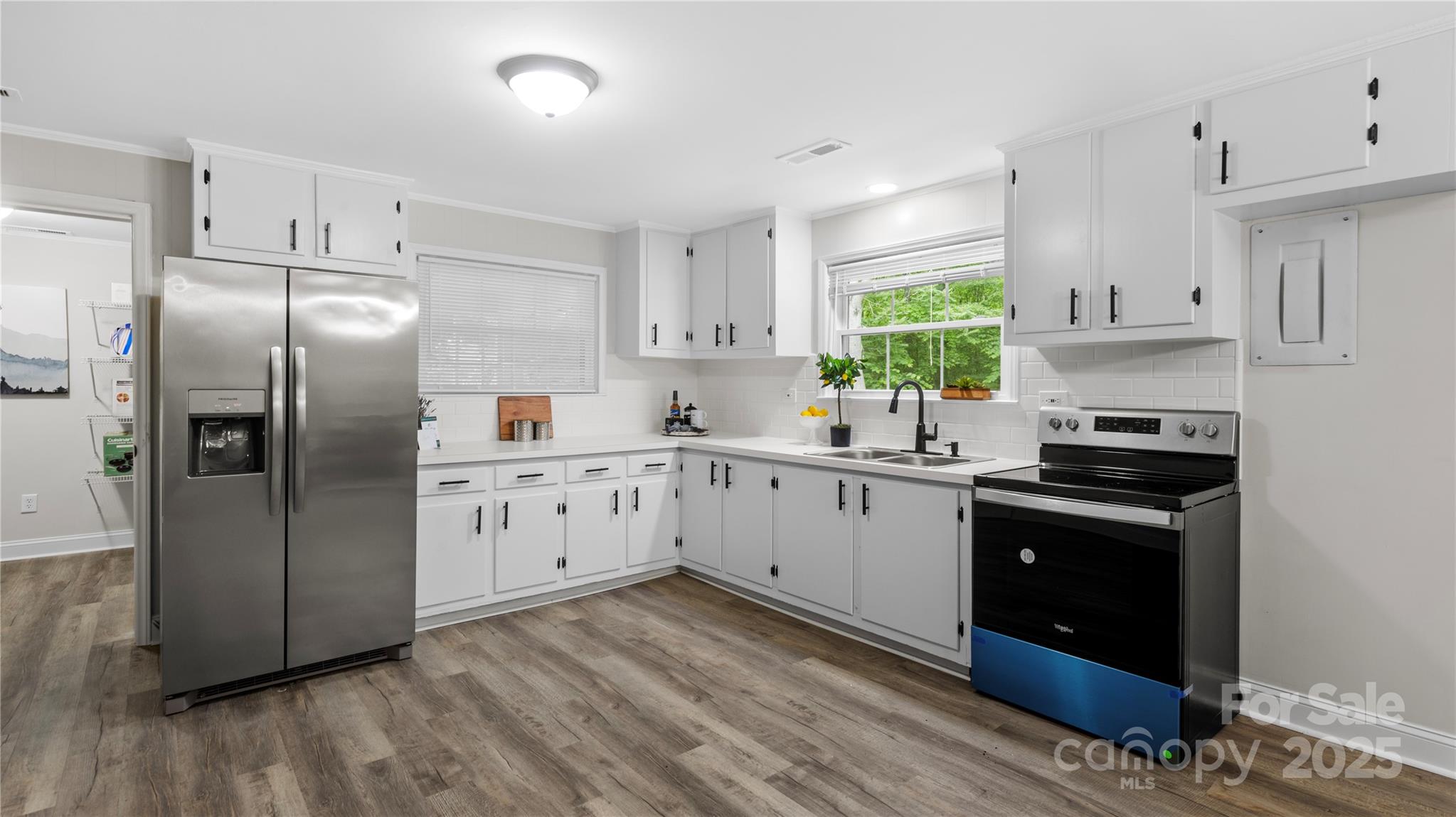 7860 Henry Harris Road Fort Mill, SC 29707 - Photo 6 of 31 a kitchen with stainless steel appliances granite countertop a refrigerator a sink dishwasher a stove and white cabinets with wooden floor