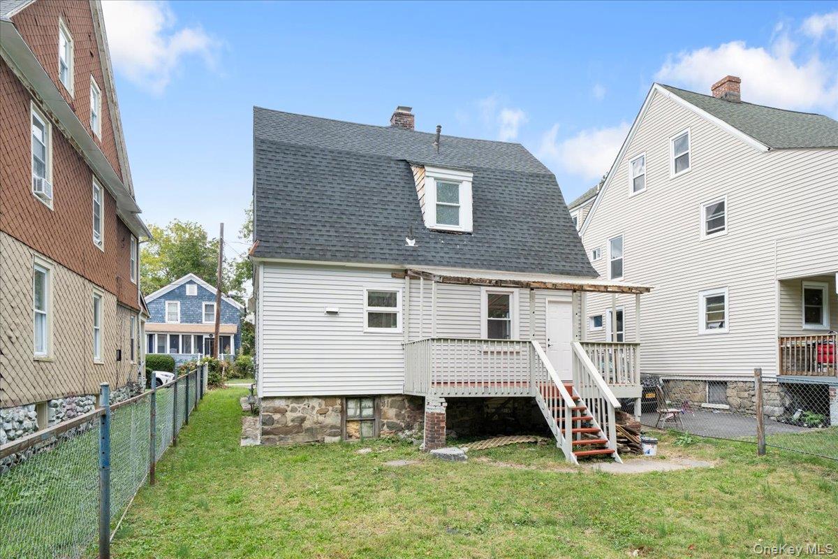 28 Spring Street Middletown, NY 10940 - Photo 38 of 43 Rear view of house backyard, a shingled roof, stairs, a chimney, and a wooden deck