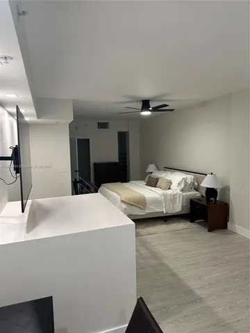 a bedroom with bed and a large mirror