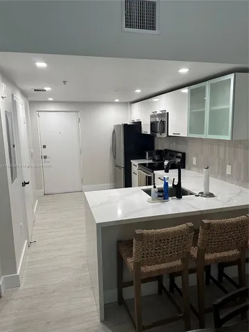 a kitchen with a table chairs and refrigerator