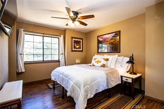 a bedroom with two beds and a table with wooden floor