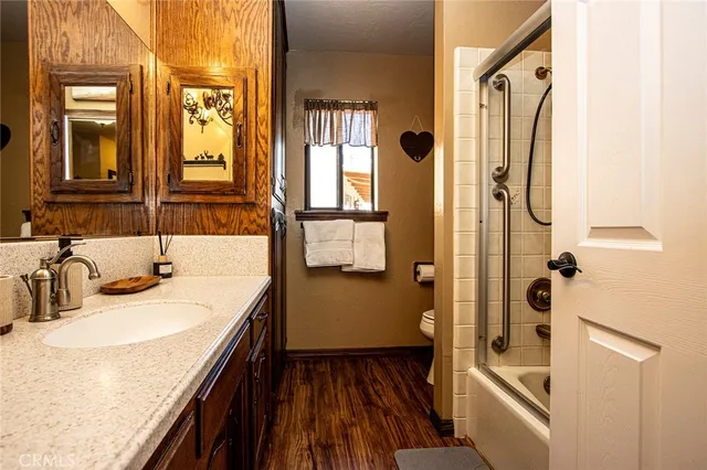 a en suite bathroom with a granite countertop sink and a mirror