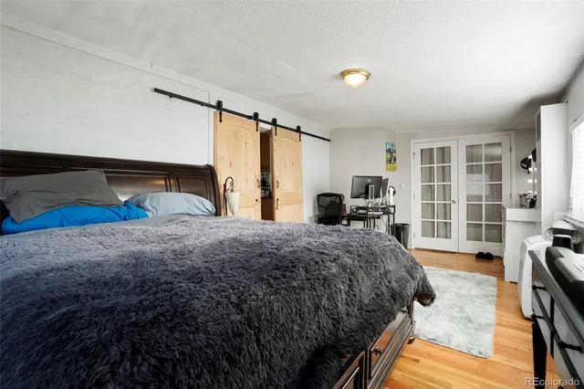 a bedroom with a bed and a large window with the outer view