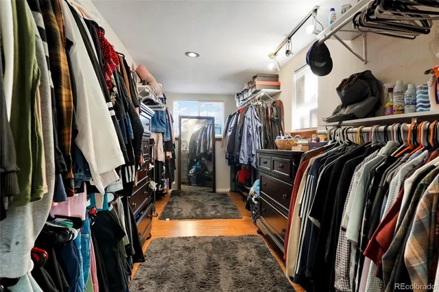 a view of walk in closet with clothes and shoes