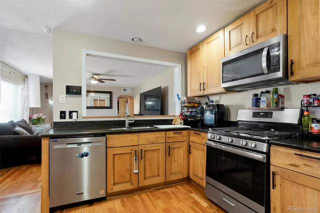 a kitchen with stainless steel appliances granite countertop a stove top oven microwave and cabinets