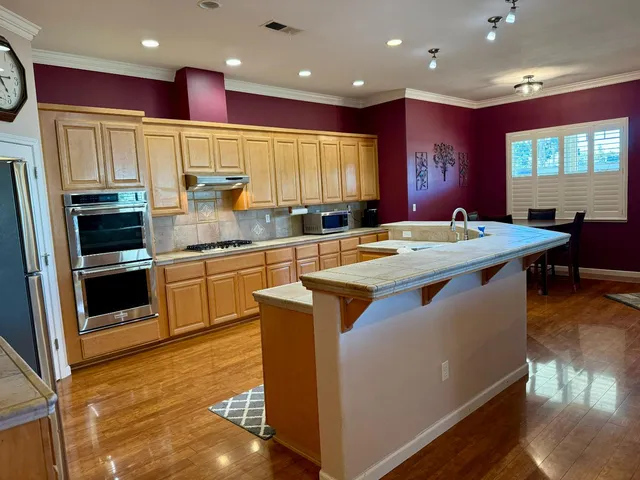 a kitchen with stainless steel appliances granite countertop a sink and a refrigerator