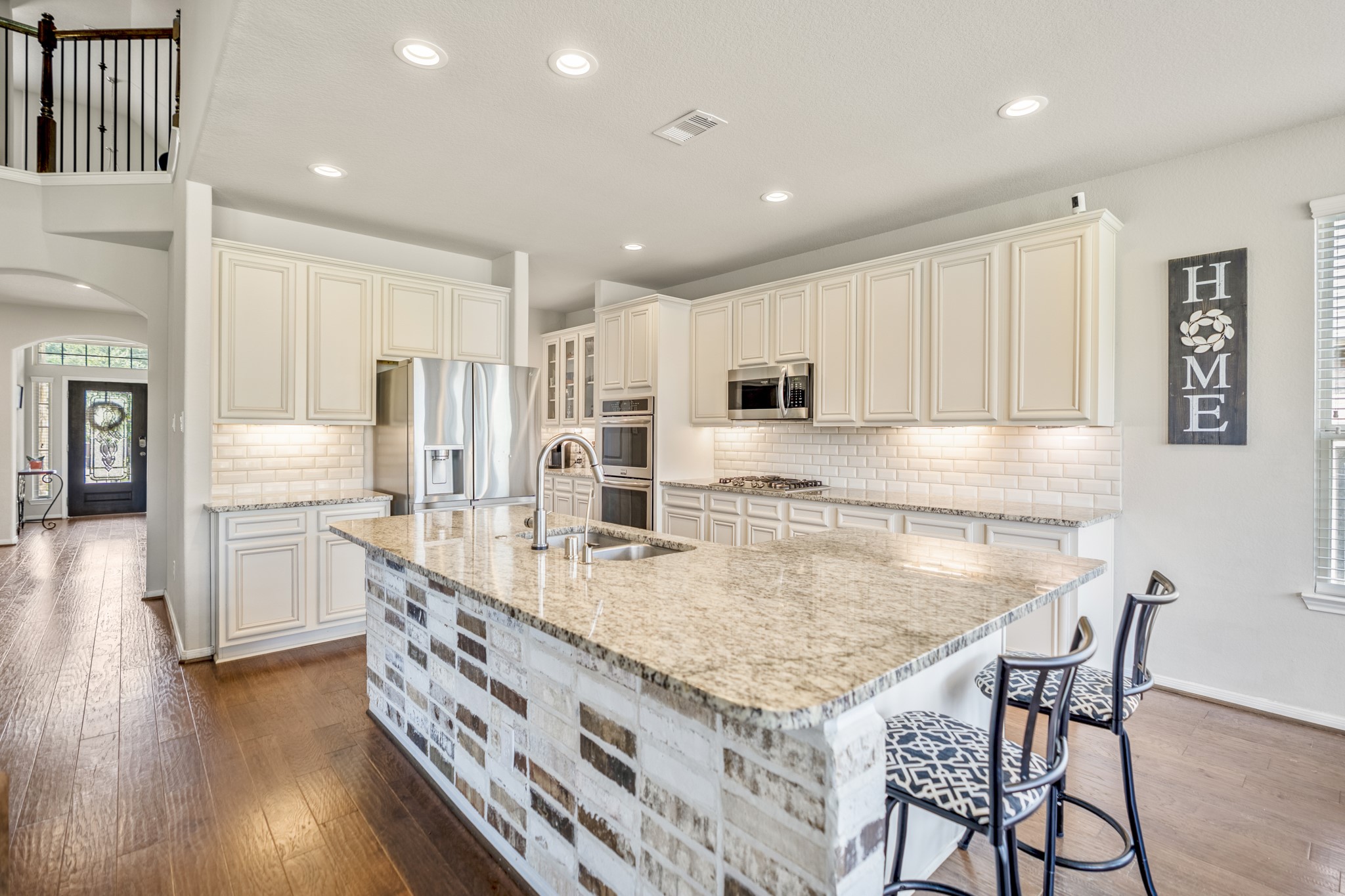 23006 Mulberry Tree Lane Spring, TX 77389 - Photo 14 of 50 a kitchen with stainless steel appliances granite countertop a stove top oven a sink a refrigerator and white cabinets with wooden floor