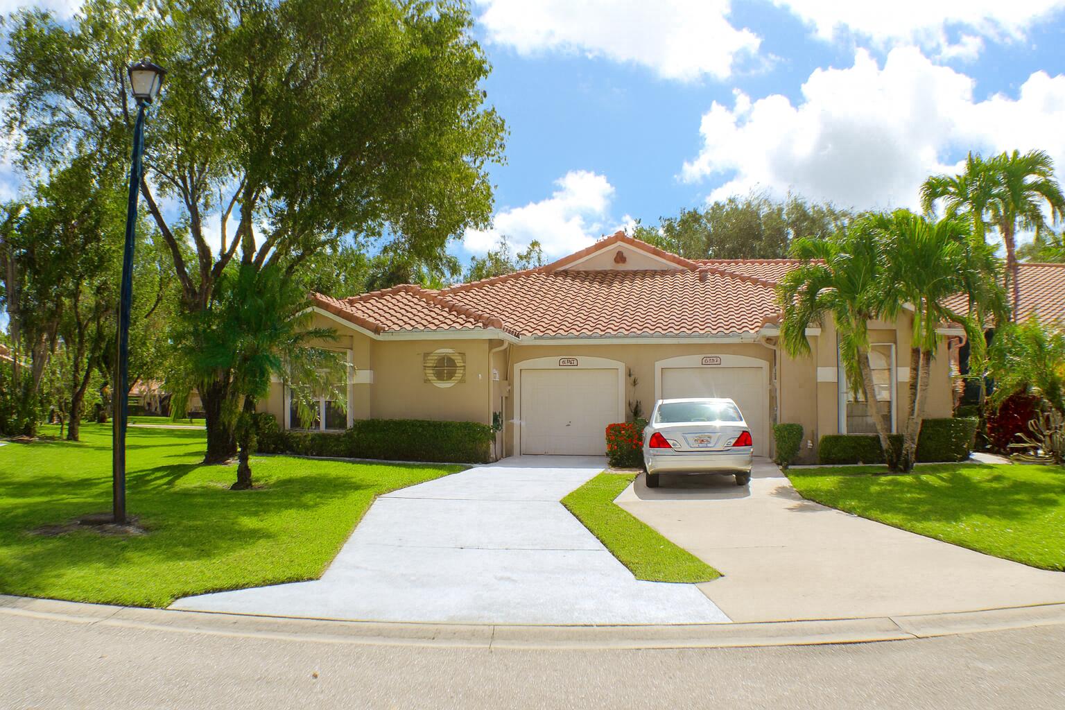 6387 Long Key Lane Boynton Beach, FL 33472 - Photo 1 of 49 a front view of a house with a yard and porch