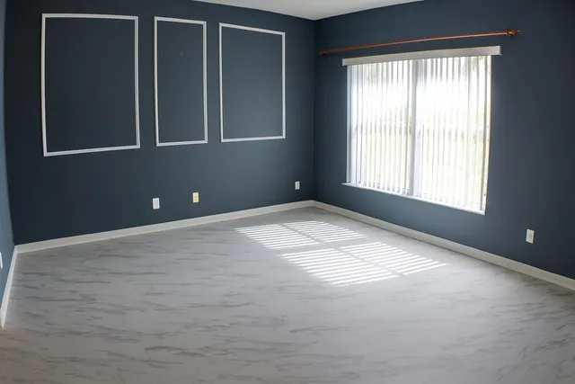 a bedroom with a bed and a dresser next to a window