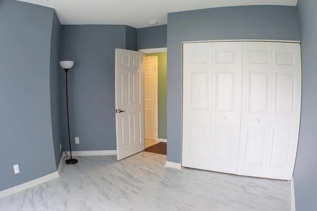 a view of an empty room with wooden floor and closet