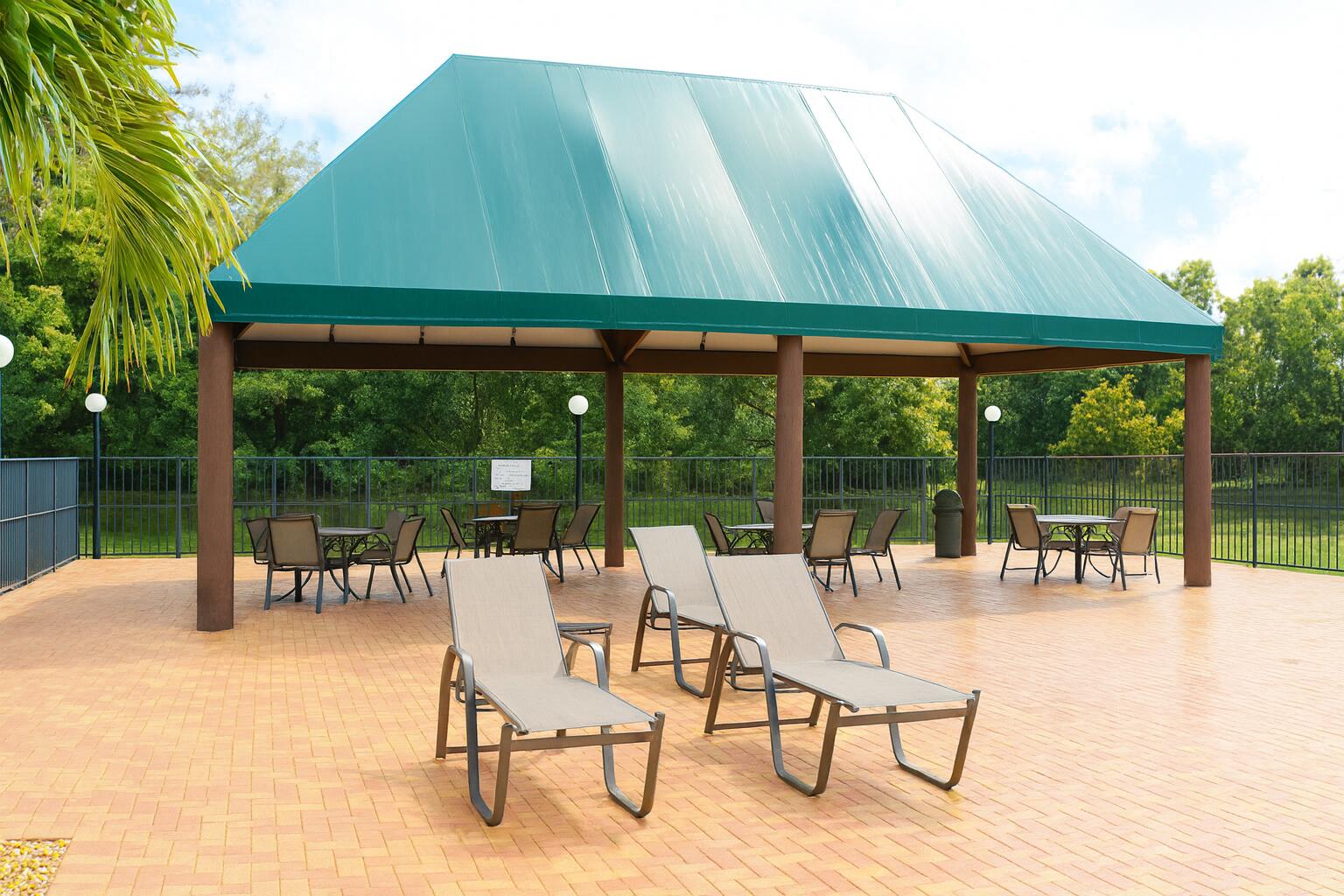 6387 Long Key Lane Boynton Beach, FL 33472 - Photo 42 of 49 a view of a patio with a table and chairs under an umbrella