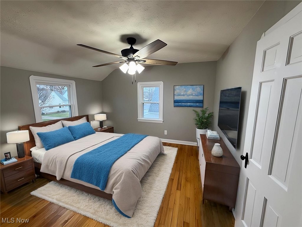 6807 Gerald Avenue Parma, OH 44129 - Photo 11 of 25 Bedroom featuring a ceiling fan, wood finished floors, baseboards, vaulted ceiling, and a textured ceiling virtually staged