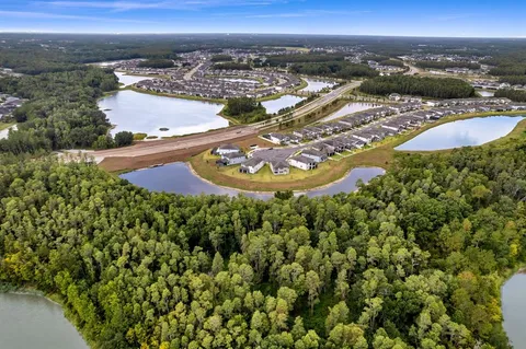 an aerial view of residential houses with outdoor space and trees