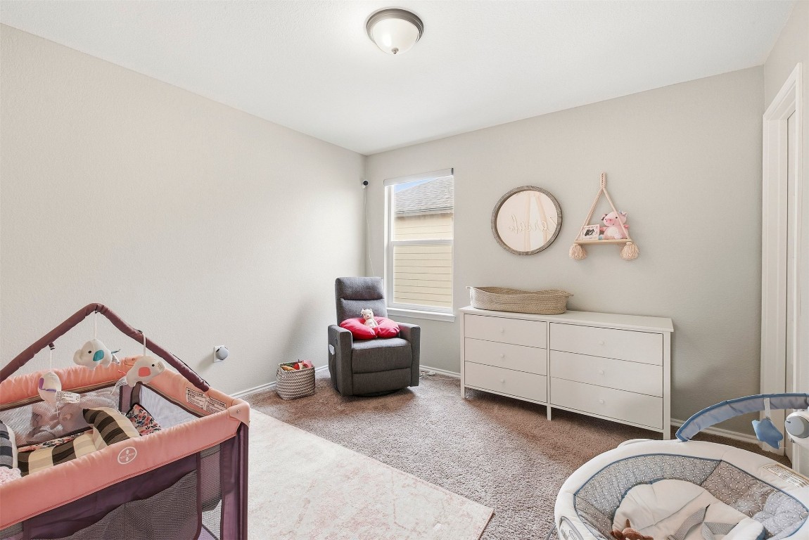 1506 Dragonfly Loop Bastrop, TX 78602 - Photo 26 of 37 a room with a baby bed baby crib and a dresser