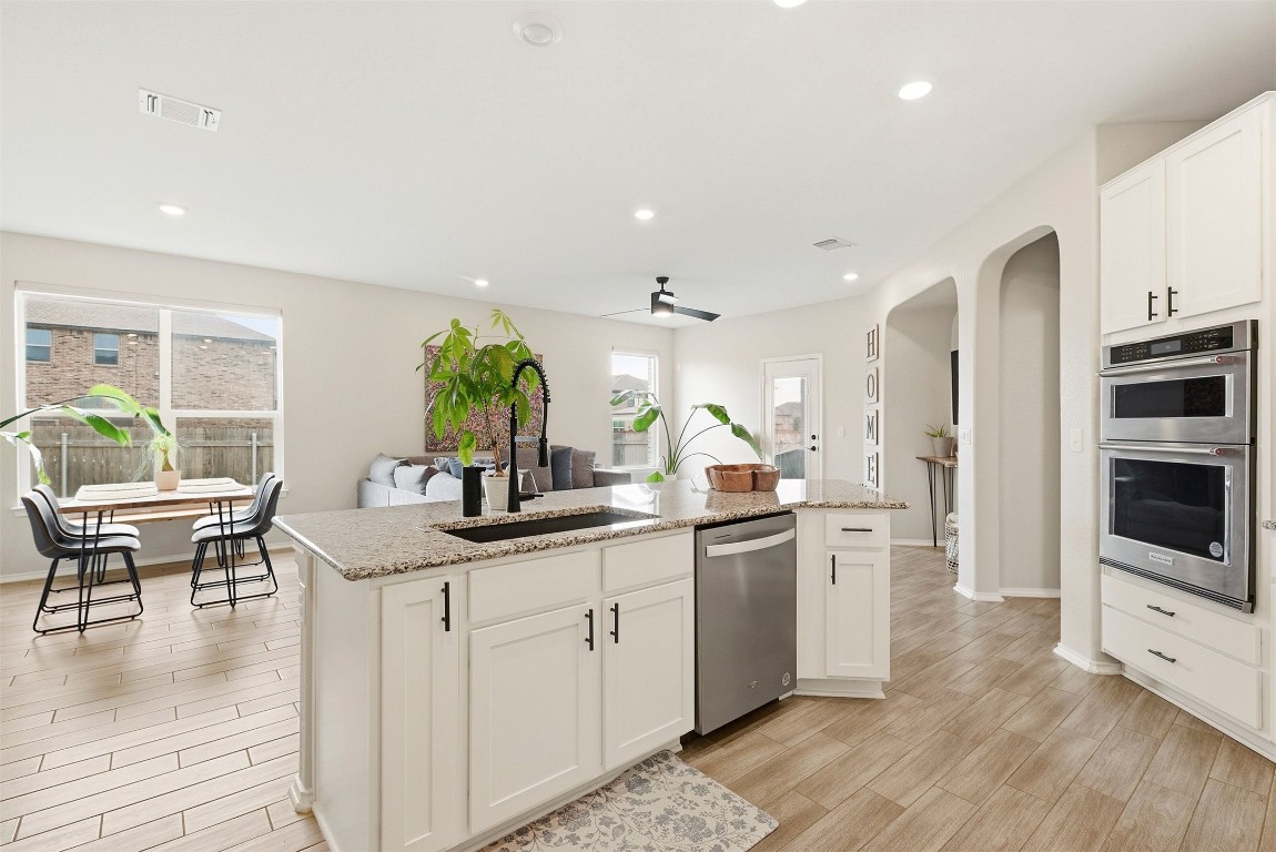 1506 Dragonfly Loop Bastrop, TX 78602 - Photo 8 of 37 a kitchen with stainless steel appliances kitchen island granite countertop a sink and cabinets