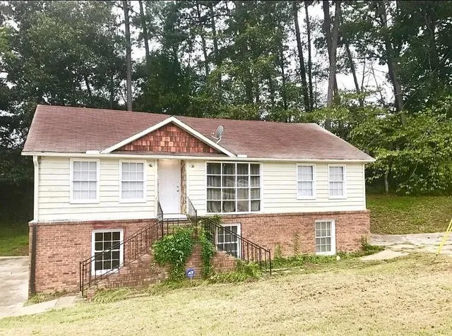 a view of a house with a yard and sitting area