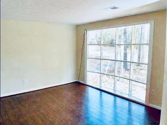 wooden floor in an empty room with a window