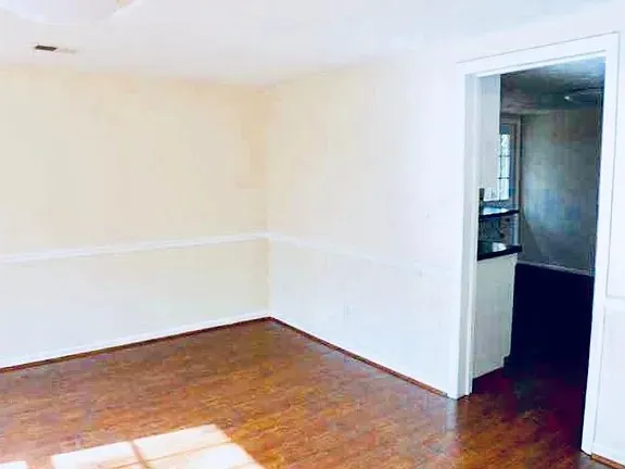 an empty room with wooden floor and closet