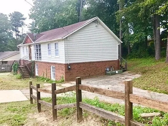 a view of house with backyard and sitting area