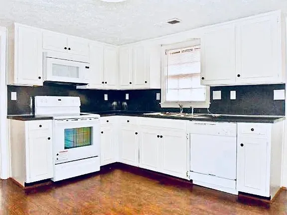 a kitchen with white cabinets and white appliances