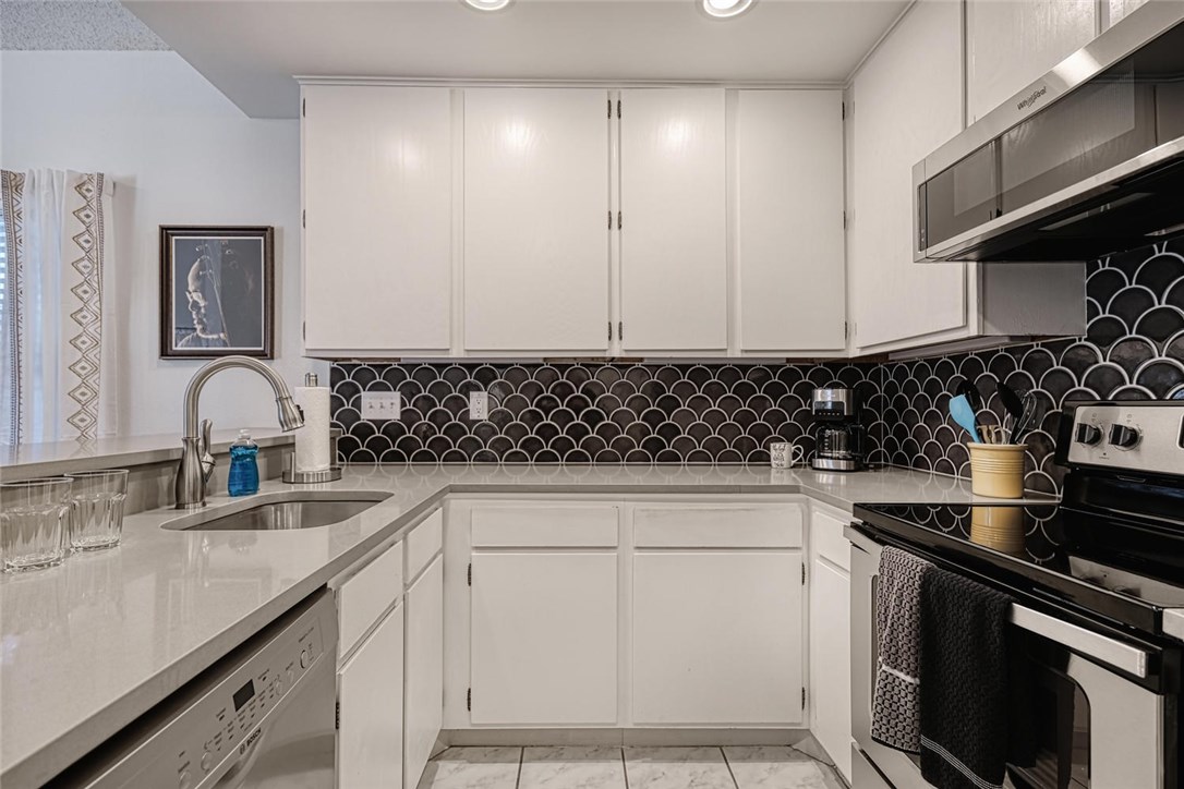 1748 Ohlen Road, Unit 74 Austin, TX 78757 - Photo 7 of 15 a kitchen with a sink stove and cabinets