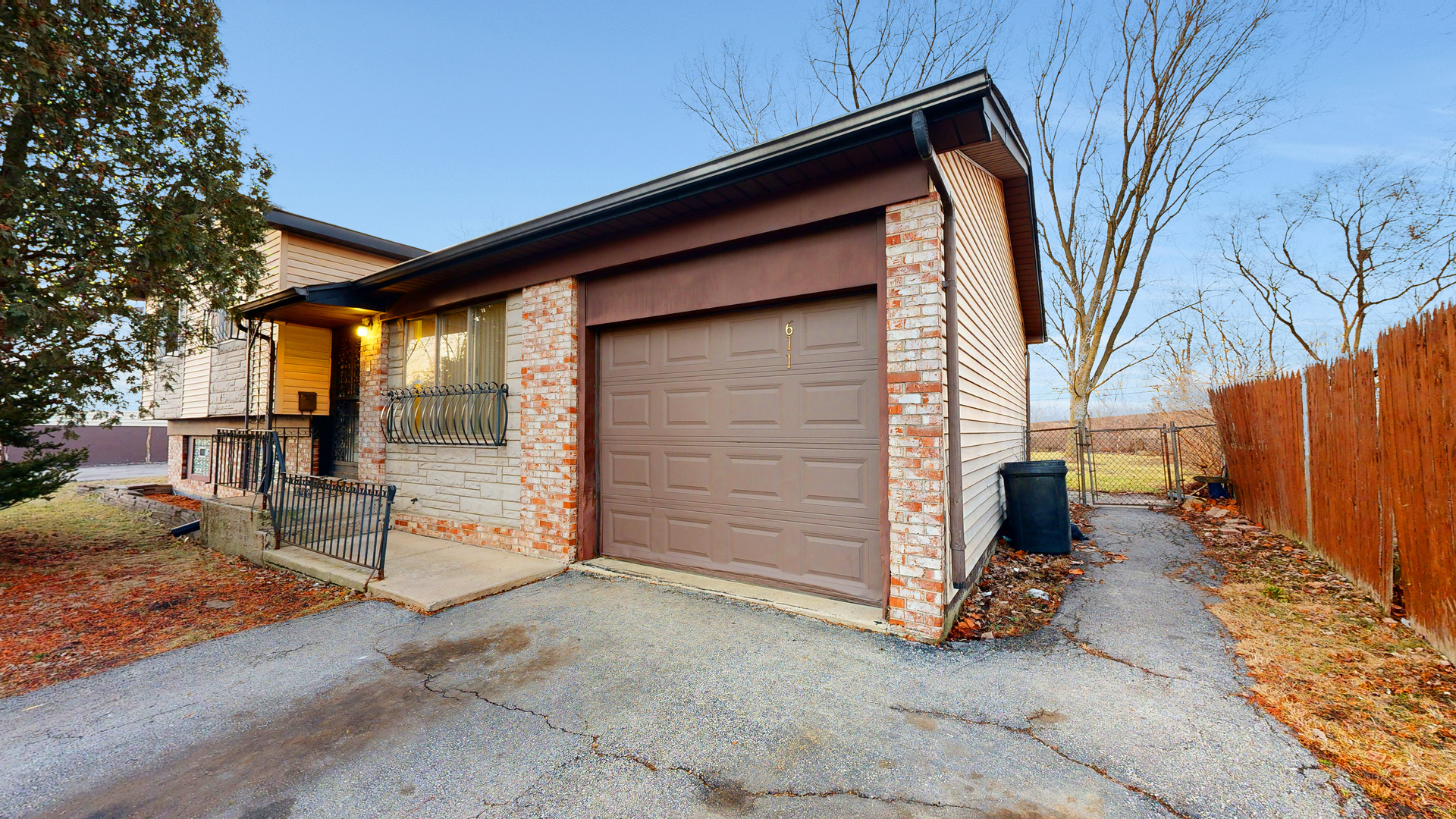 a backyard of a house with a tree and wooden fence