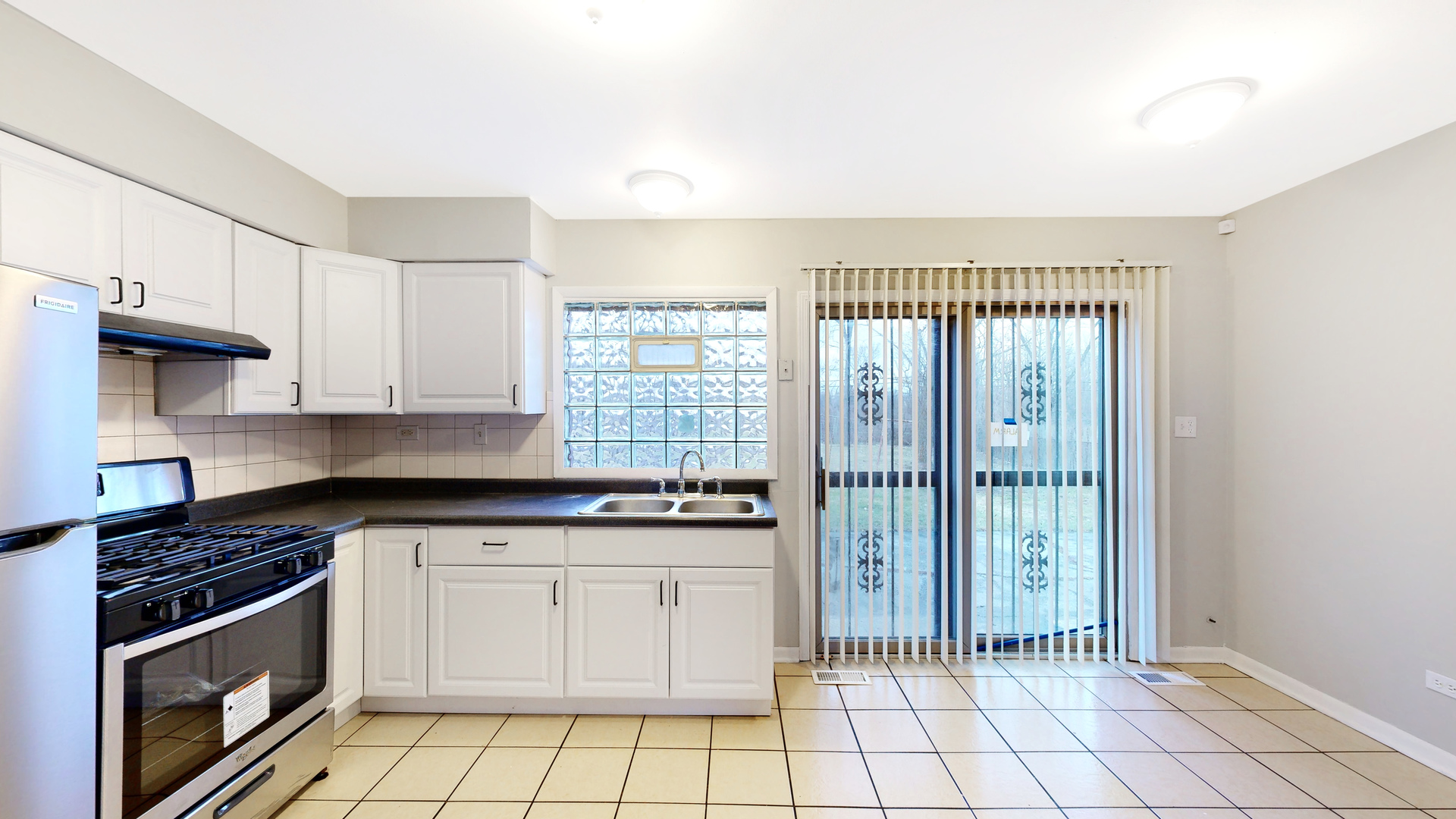 611 Andover Street Chicago Heights, IL 60411 - Photo 5 of 30 a kitchen with granite countertop a stove a sink and a refrigerator