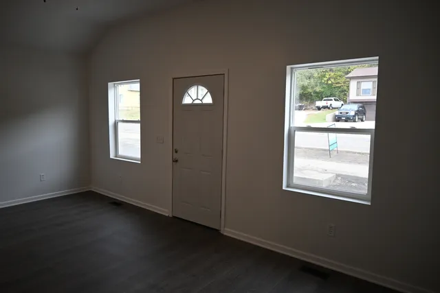 a view of an empty room with wooden floor