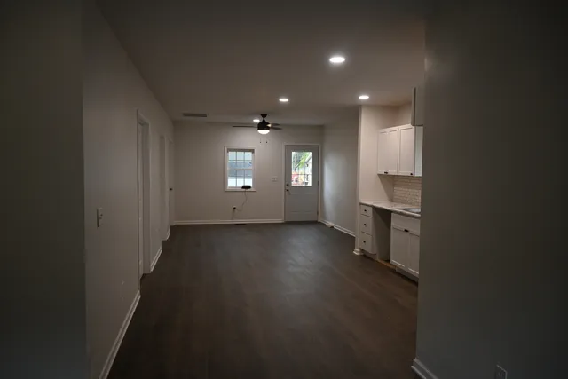 an empty room with wooden floor and windows