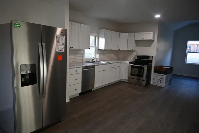 a kitchen with stainless steel appliances granite countertop a refrigerator a stove a sink and a refrigerator