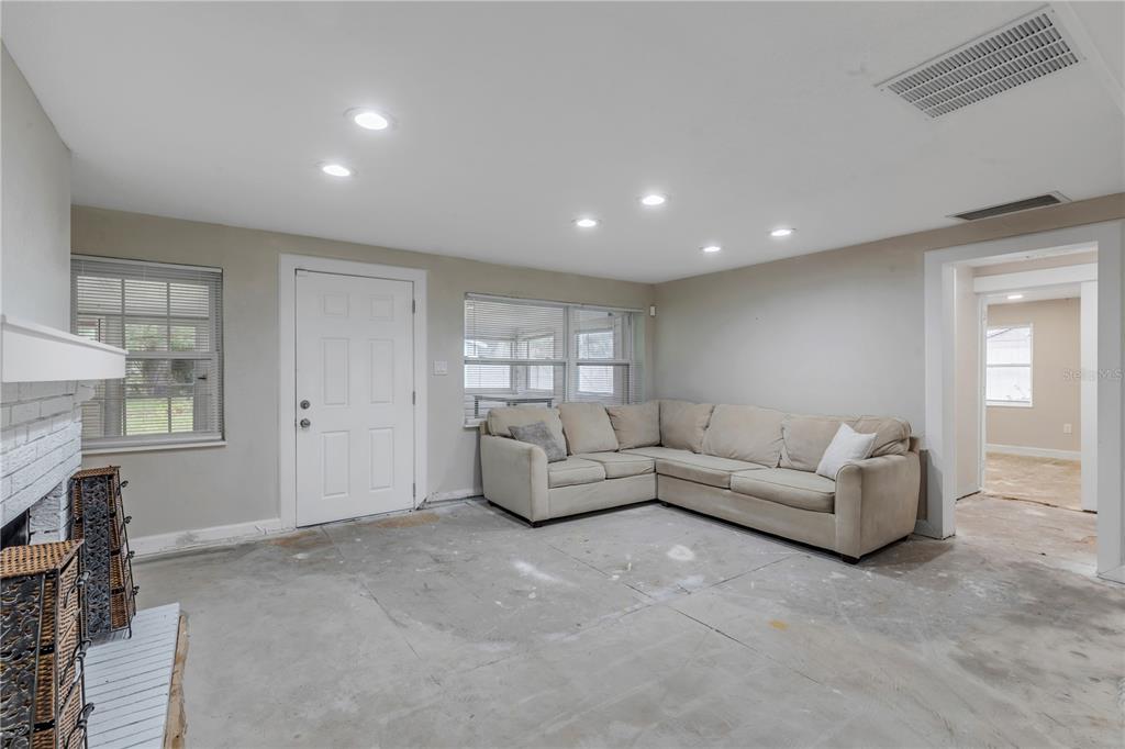 103 Flagler Avenue Edgewater, FL 32132 - Photo 13 of 53 a living room with furniture a fireplace and a large window