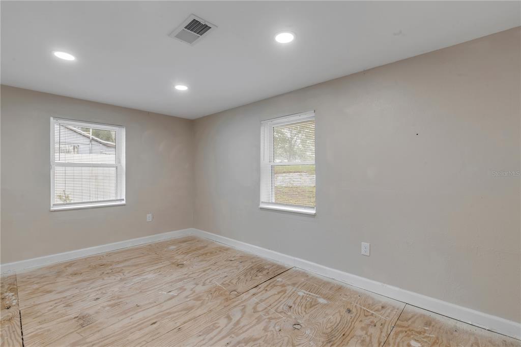 103 Flagler Avenue Edgewater, FL 32132 - Photo 17 of 53 an empty room with wooden floor and windows